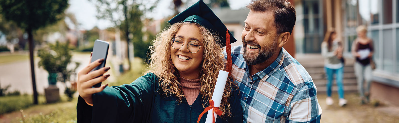 Graduate taking a selfie with dad.