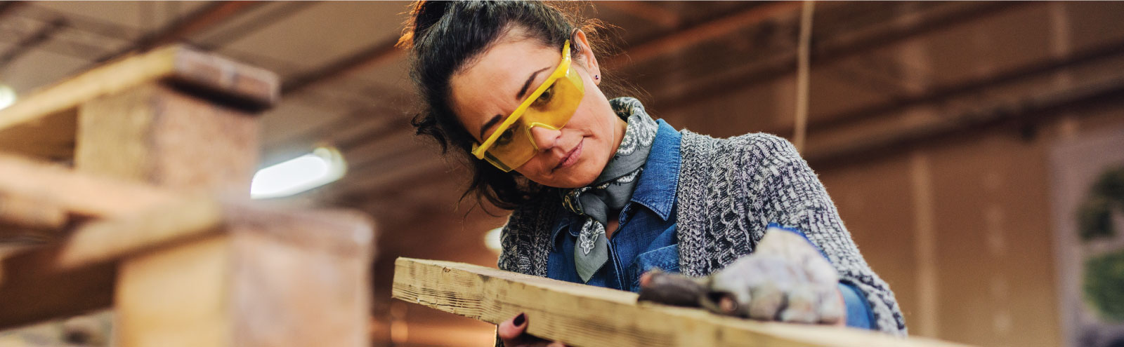 Woman sanding board in shop