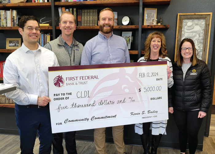 First Federal employees and members of CLDI holding a donation check for $5,000.