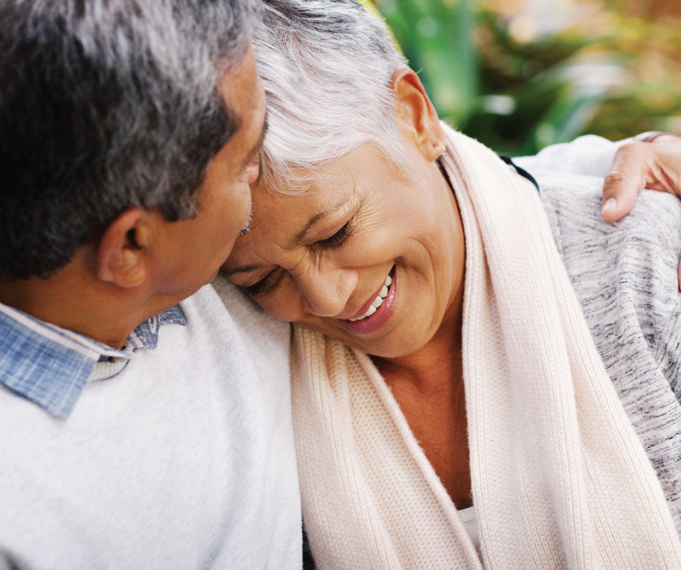 Retired couple embracing on bench