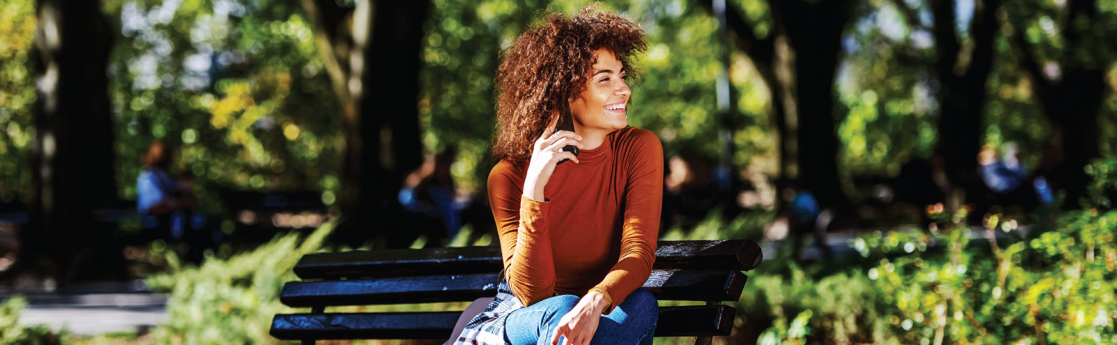 Woman talking on phone on park bench.