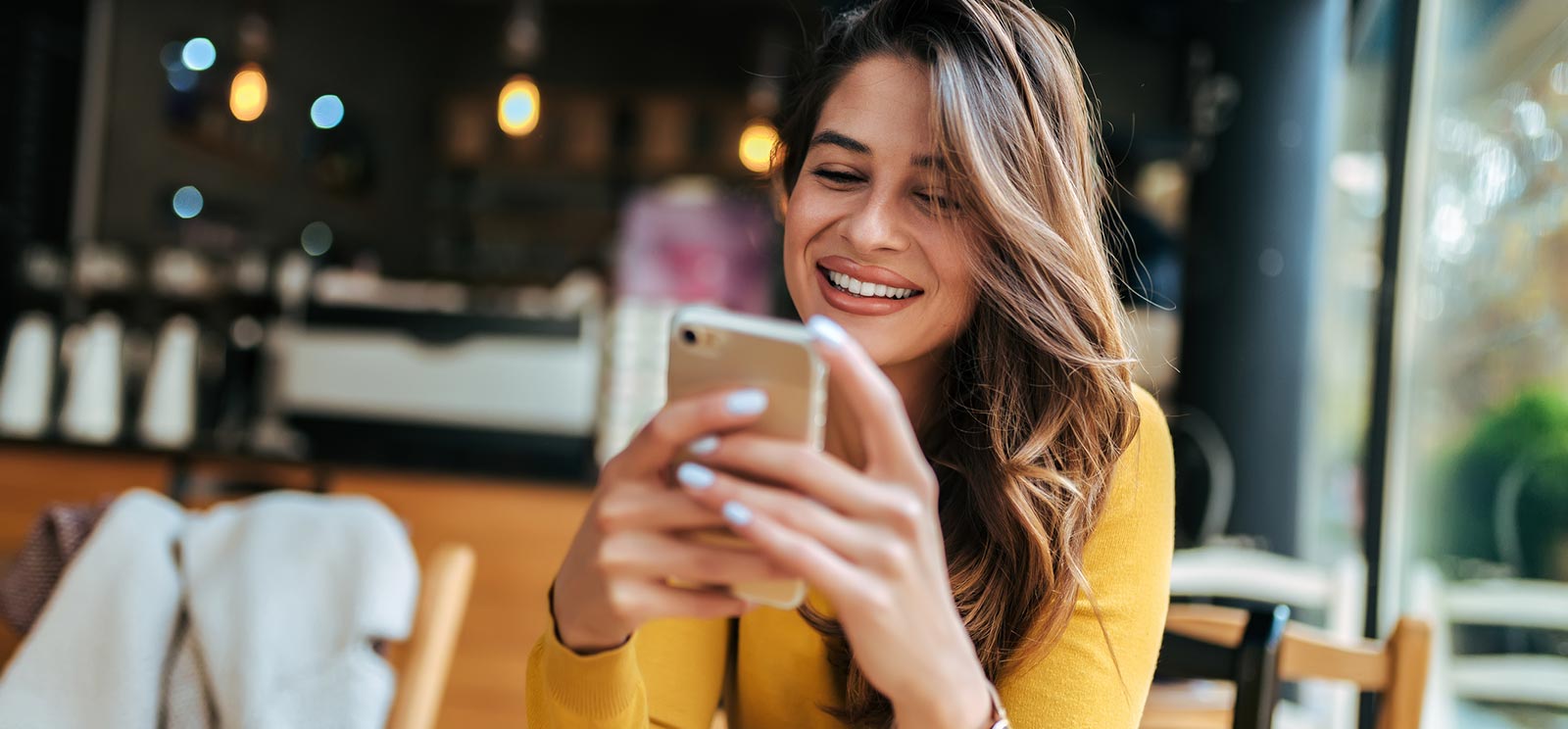 A lady using a smartphone in a restaurant