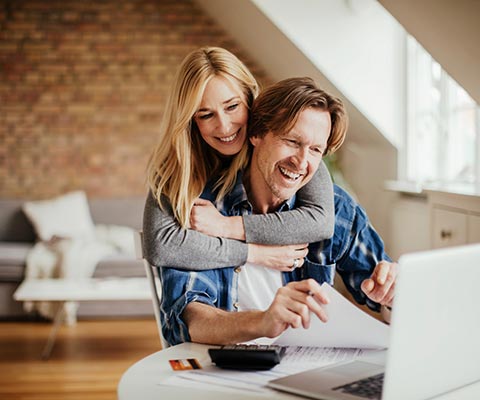 A couple going over financials at home on a laptop computer