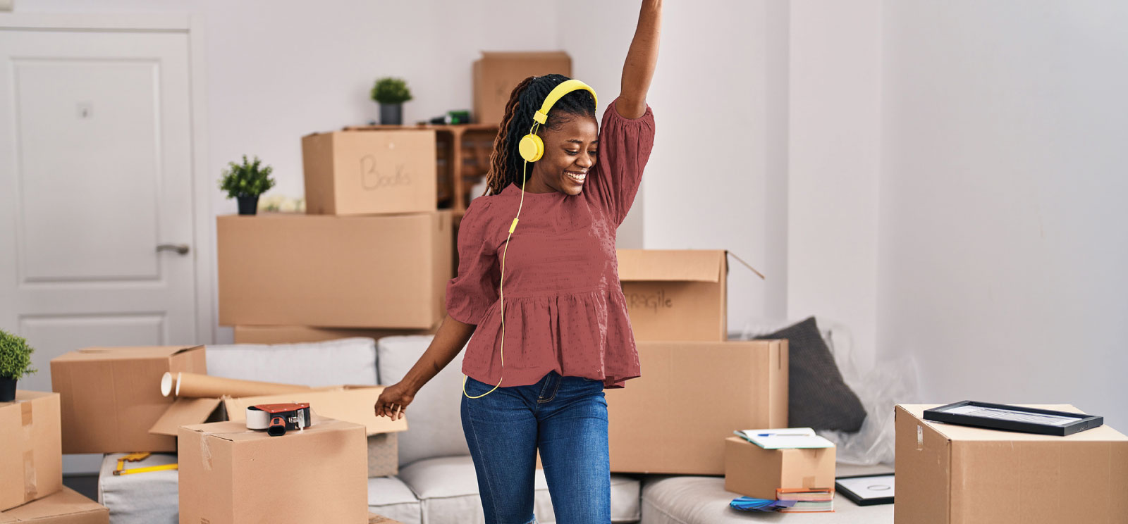 Woman dancing in front of moving boxes