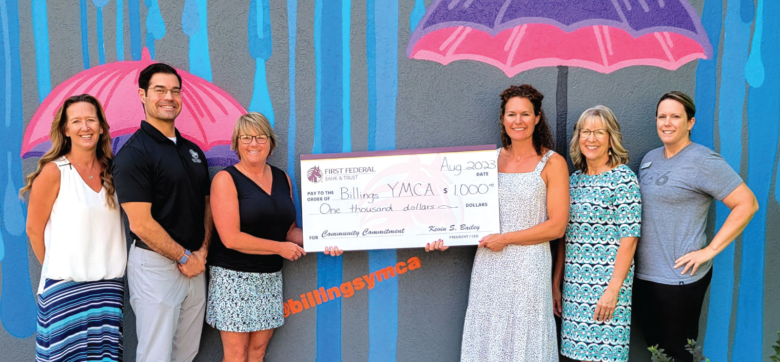 Group of people holding a YMCA donation check.
