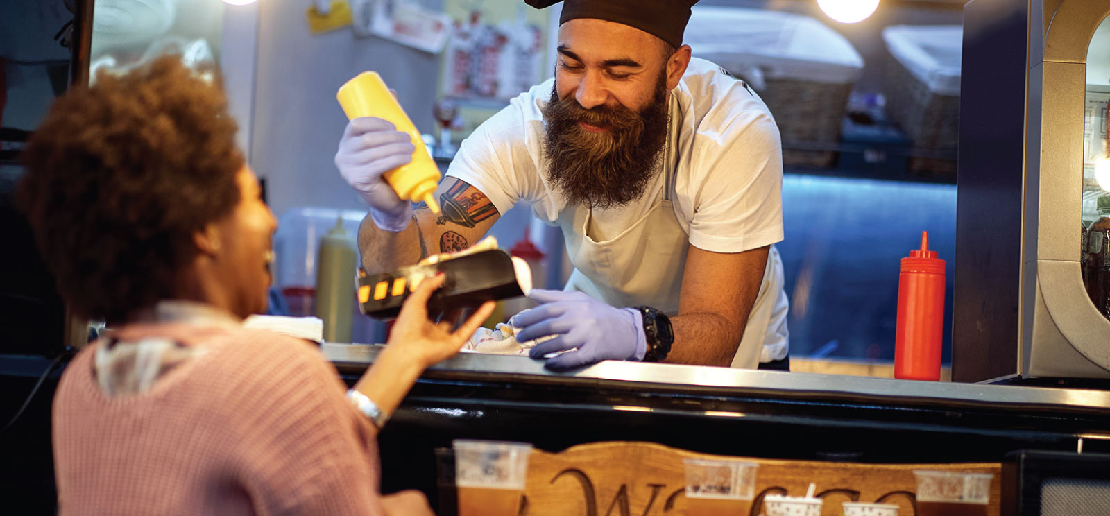 Owner of a food truck serving a customer.