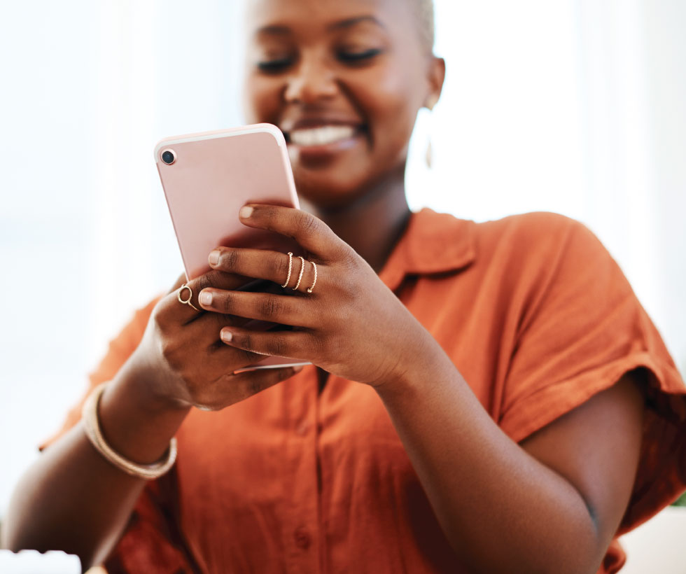 Woman smiling and looking at her mobile phone