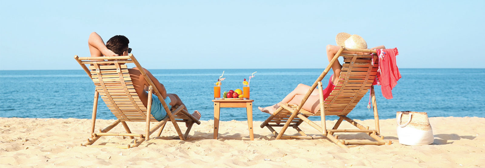 Back of couple relaxing on the beach.