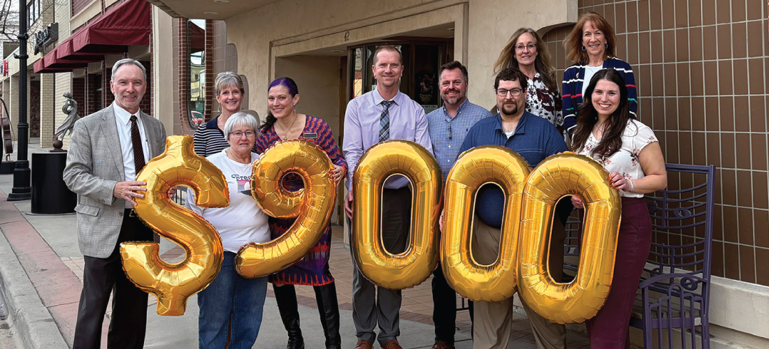 Group of people holding $9,000 balloons in front of the WYO Theater.