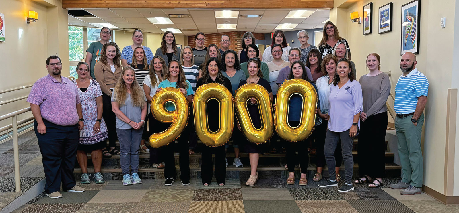 Group of First Federal and Bighorn Development Center employees holding $9000 balloons.