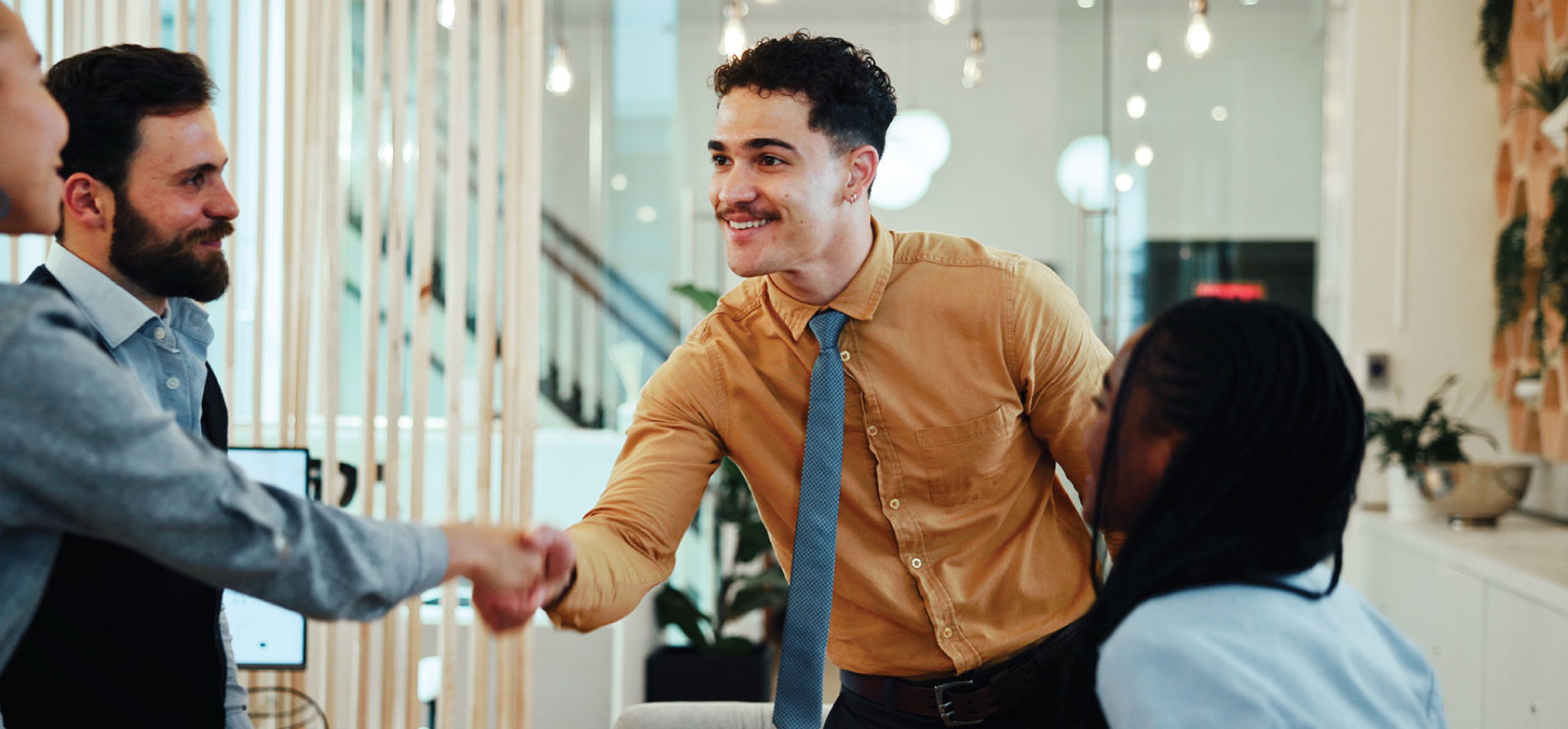 Man shaking a co-workers hand at the office.