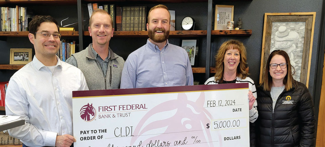 People holding a donation check to CLDI.