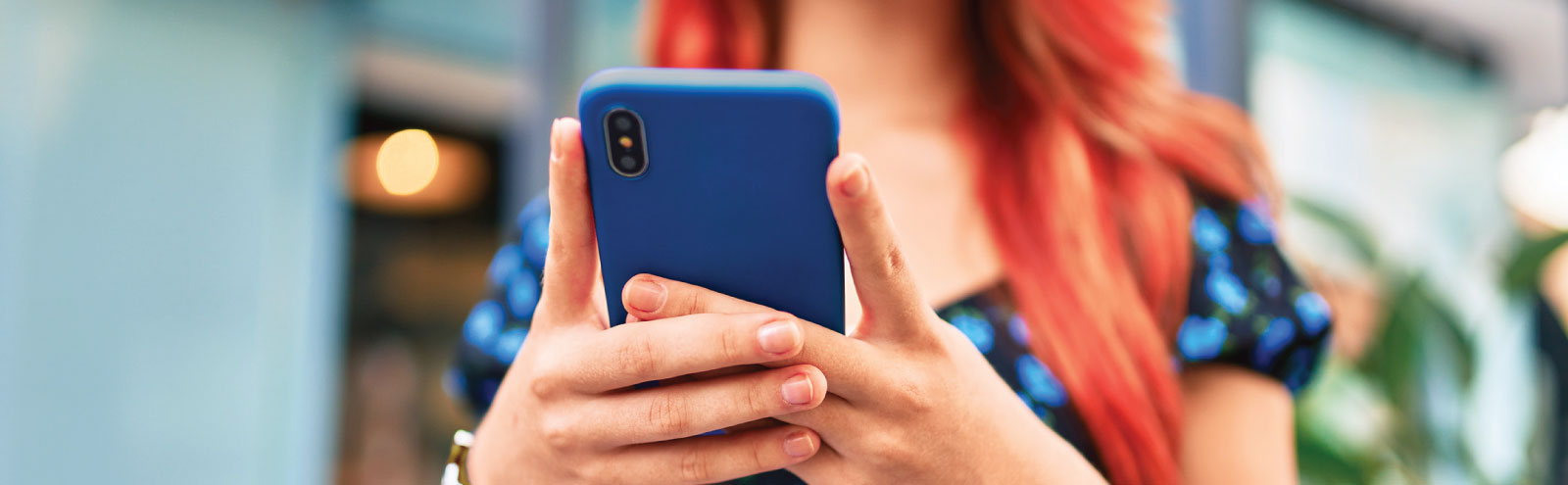 Young redhaired woman using mobile phone.